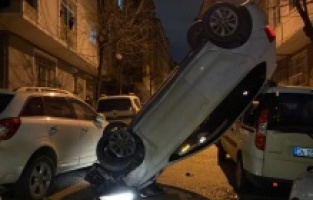 Park halindeki araçlara çarpıp dik bir şekilde havada asılı kaldı